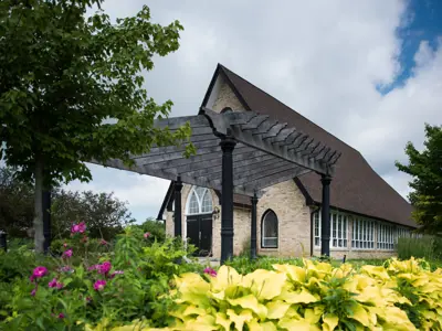 chapel in the background with flowerbed and pergola in the foreground