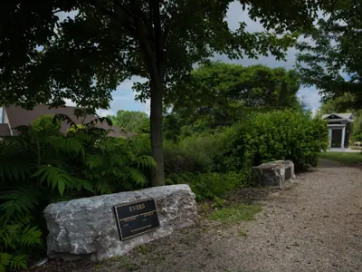 large stone that people can sit on with a memorial sign on it