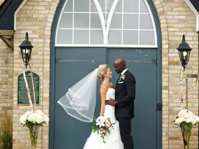 bride and groom standing in front of chapel