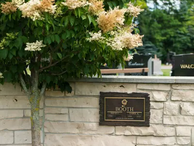 short stone wall with metal memorial sign on it