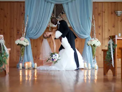 Husband dipping wife for photo at altar