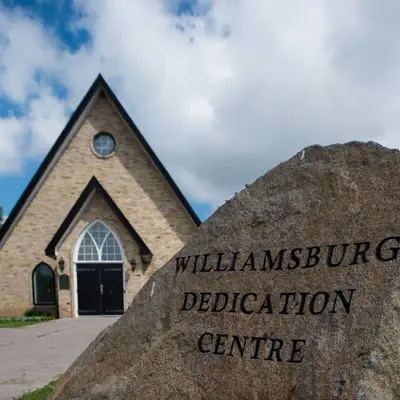 Stone that says Williamsburg Dedication Centre with chapel in background