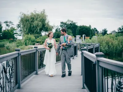 bride and groom standing on bridge